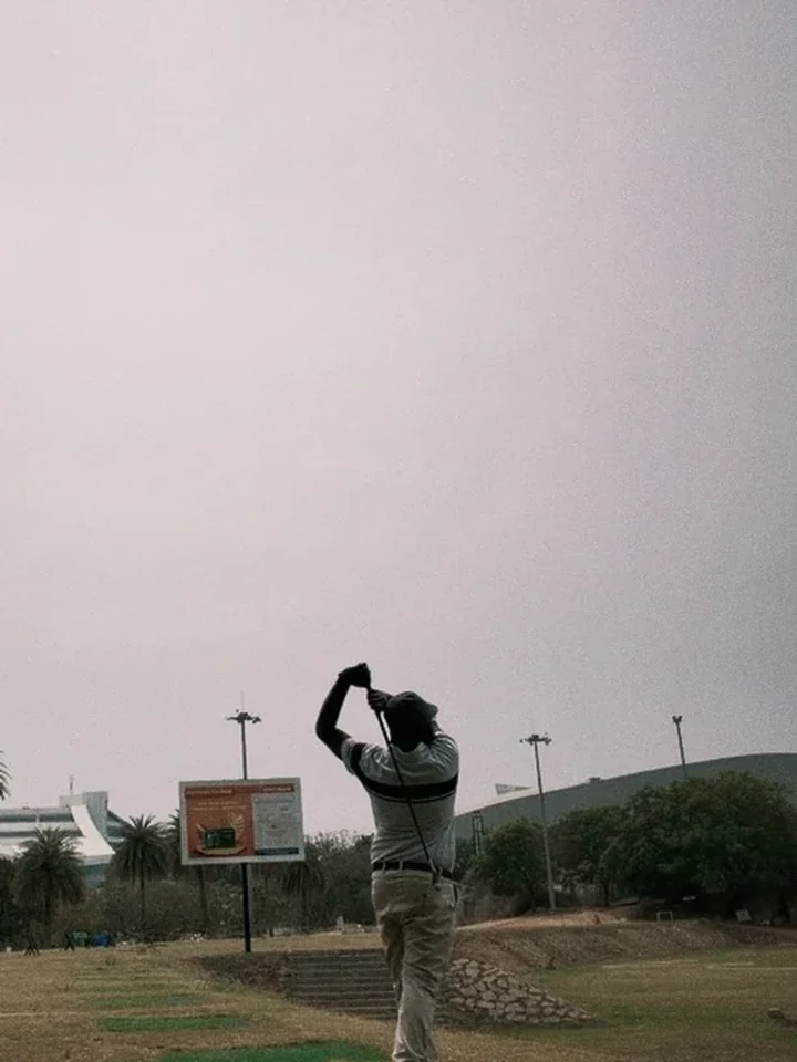 Tejj mid-swing on the golf course